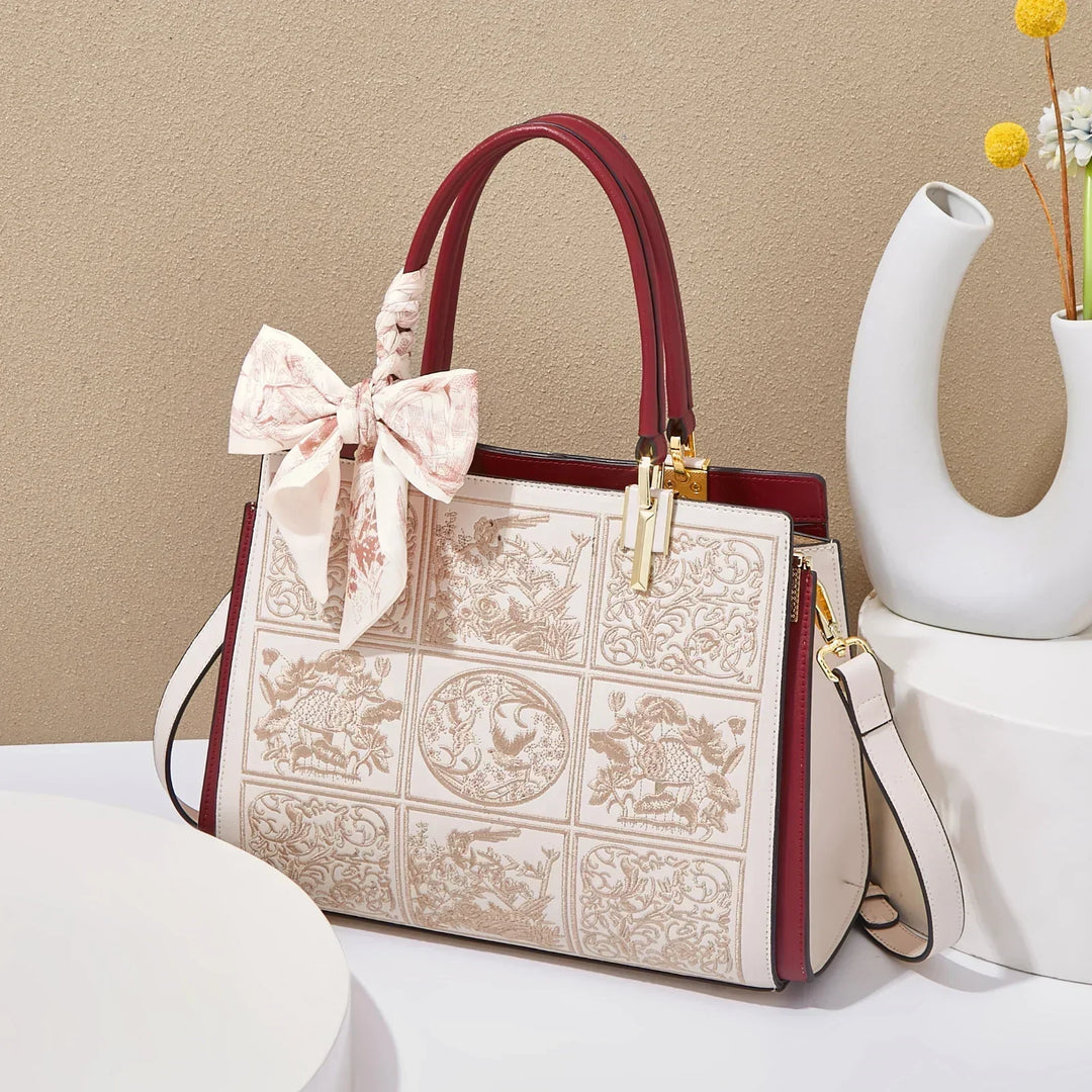 Sylvia™ – Wyjątkowa torebka crossbody z haftem i kokardą